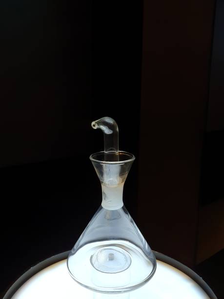 istock Side view of glass oilcan, illuminated from below, with black background. 1225356247