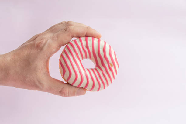 istock Person holds donut in his hand 1225356383