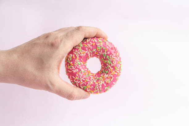 istock Person holds donut in his hand 1225356388