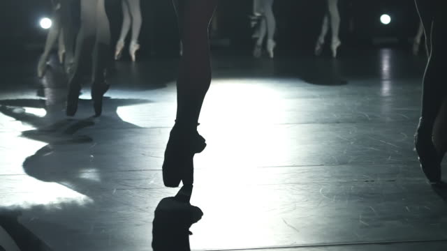 closeup of ballerinas legs dancing graceful classic performance on stage Spbd. feet in spotlight