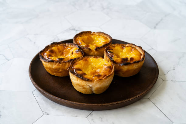 istock Pasteis de Nata or Belem Tart. Portuguese Custard made with Egg, Cinnamon, Sugar and Flour on Wooden Plate. 1225358216