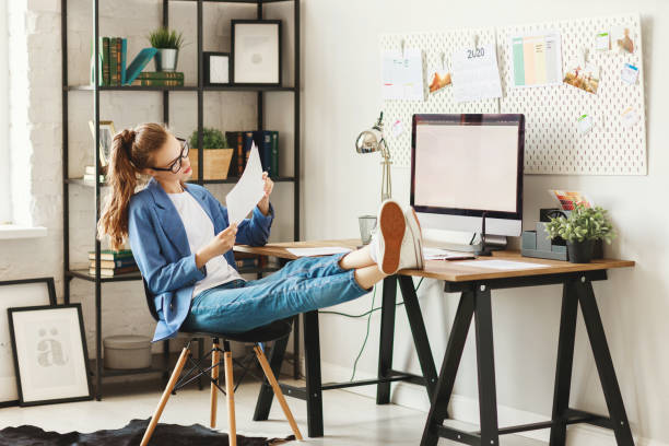 istock Happy young woman working with documents and computer at home 1225359048