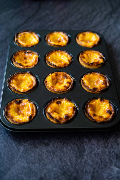 istock Pasteis de Nata or Belem Tart. Portuguese Custard made with Egg, Cinnamon, Sugar and Flour in Muffin Tray / Cupcake Mold. 1225359077