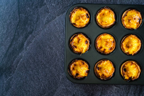 istock Pasteis de Nata or Belem Tart. Portuguese Custard made with Egg, Cinnamon, Sugar and Flour in Muffin Tray / Cupcake Mold. 1225359662