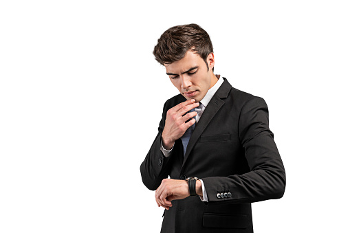 Isolated portrait of thoughtful young European businessman looking at his watch. Concept of appointment and time management. Copy space
