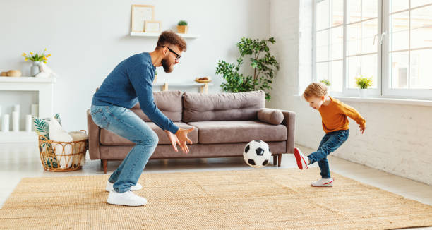 Father teaching son to play football