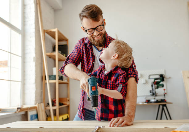 istock Happy kid helping father in carpentry studio 1225361586