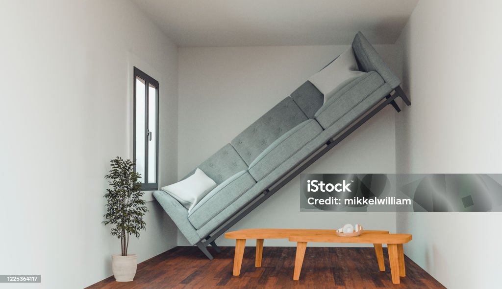 Concept of an apartment or living room that is too small to fit a sofa Concept of a living in a home that is not big enough for your dreams and items. Sofa cannot fit into the living room and stand up against a wall. Humor Stock Photo