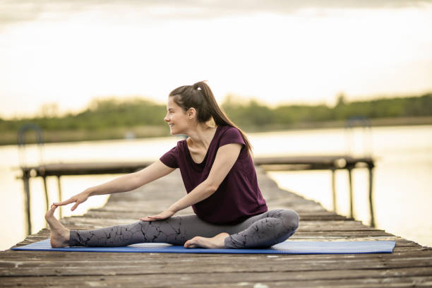 istock Woman stretching on lake pier 1225367280