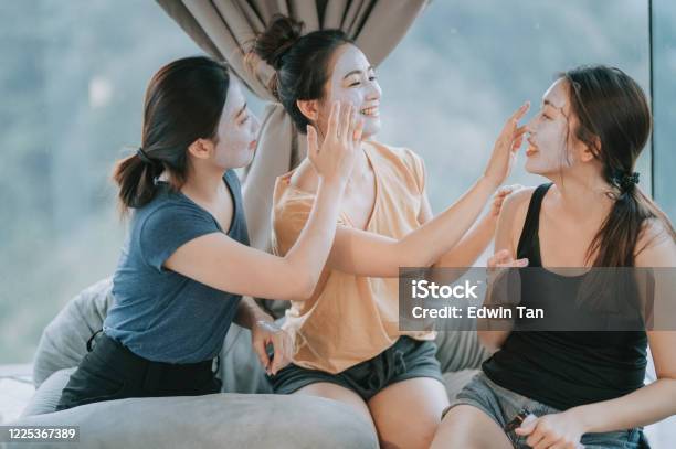 3 Asian Chinese Beautiful Women Applying Clay Mask In Bedroom Having Fun Time Togetherness Stock Photo - Download Image Now