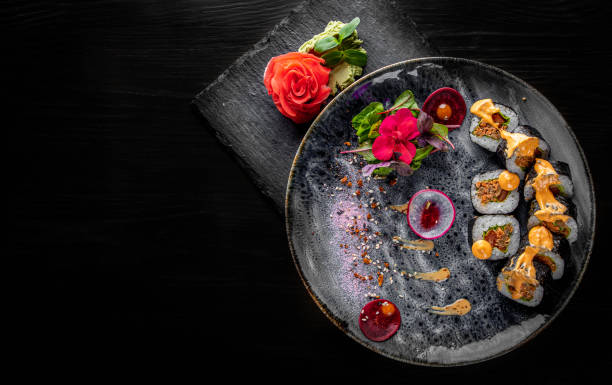 istock sushi roll in plate on black wooden table background 1225371292