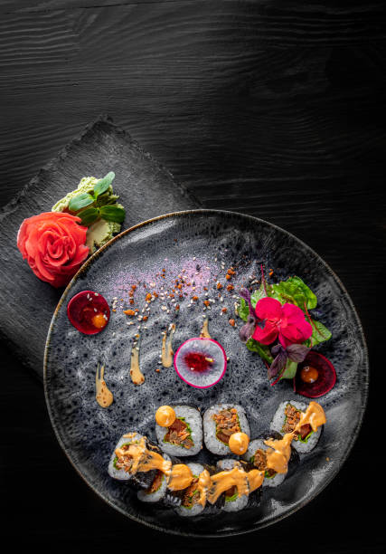 istock sushi roll in plate on black wooden table background 1225371303