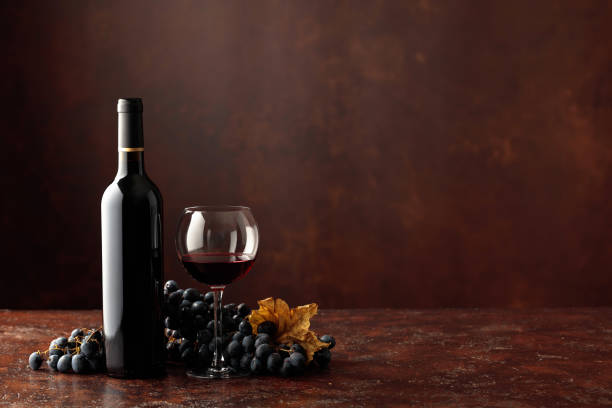 Red wine and grapes on a brown background. Red wine and grapes on a brown background. Free space for your content. merlot grape photos stock pictures, royalty-free photos & images