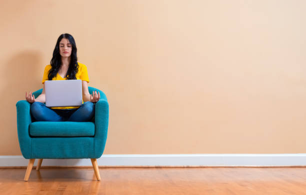 istock Young woman with laptop in a meditation pose 1225375672