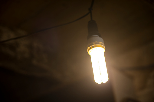 Small 220-volt incandescent bulb against a dark grey background
