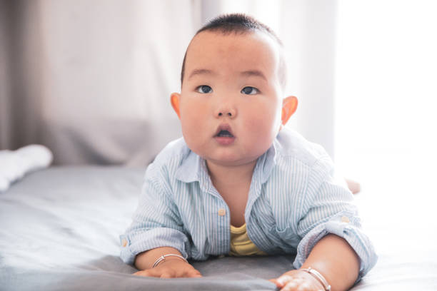 istock Asian baby lying in bed 1225380160