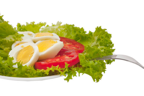 Vegetable salad with boiled eggs in a white dish. Selective focus.