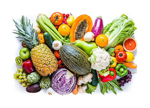 Top view of a large group of multicolored fruits and vegetables like papaya, tomatoes, red and green apples, carrots, mushrooms, eggplants, pineapple, cherries, lime, garlic, oranges and kiwi. The composition is isolated on white background.