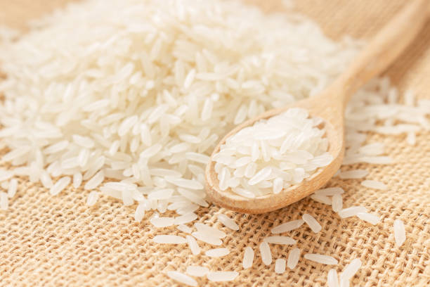 istock Close up raw rice grain on wooden spoon and sack cloth 1225384971