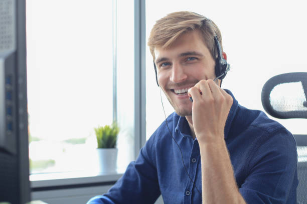 istock Smiling friendly handsome young male call centre operator. 1225386988