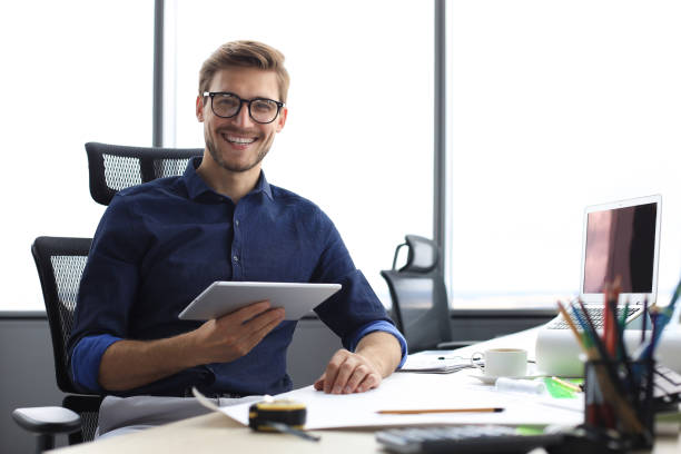 istock Young modern business man working using digital tablet while sitting in the office. 1225387644
