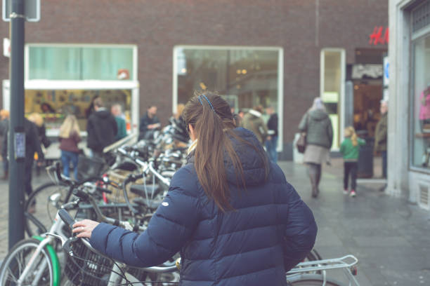 mulher quer pegar a bicicleta para fazer uma ronda na cidade, fazendo compras ou para trabalhar - downtoun - fotografias e filmes do acervo