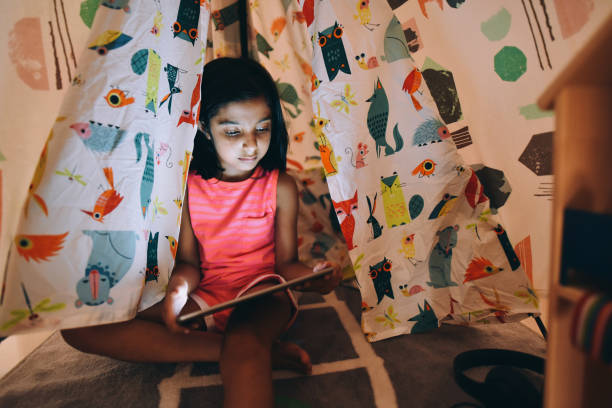 istock Girl using digital tablet in the tent 1225390752