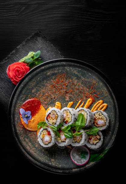 istock sushi roll in plate on black wooden table background 1225390913