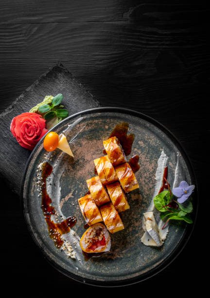 istock sushi roll in plate on black wooden table background 1225392536