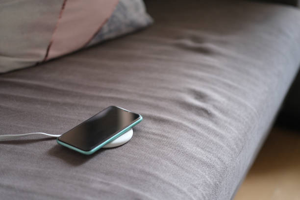 istock one smartphone on wireless charger on sofa. 1225393787