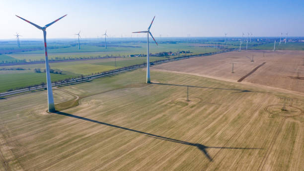 istock Two wind turbines with shadow cast on the field 1225397231