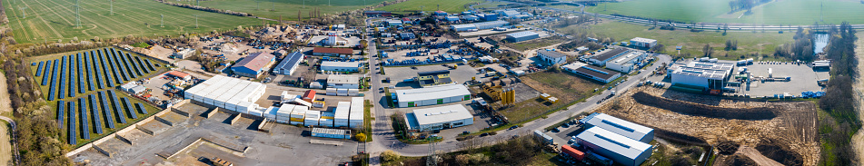 Zeestow, Brandenburg/Germany - 26.03,2020: The industrial area in Zeestow Brandenburg photographed from the air as a panoramic picture with factory buildings, solar field and individual company sites.