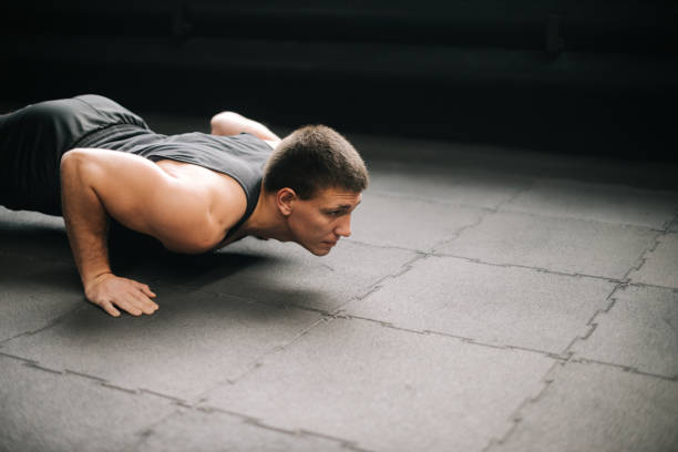 istock Muscular young man with beautiful body and naked torso doing push-ups exercise. 1225398565