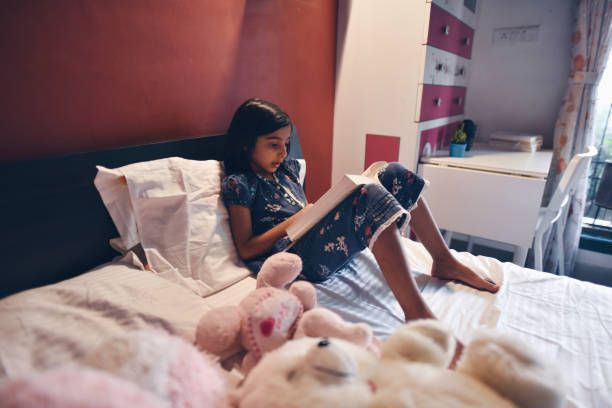 istock Girl reading sitting on bed 1225399111