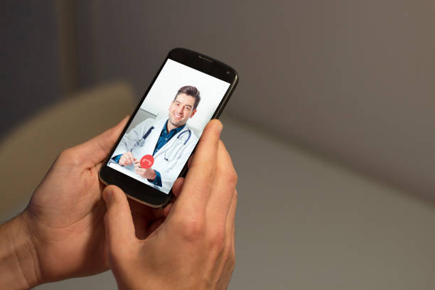 istock Hands holding mobile phone with doctor video call on the screen 1225400414
