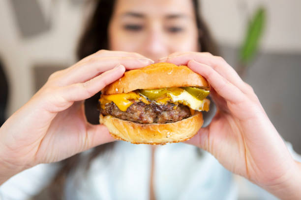 istock Woman eating beef burger 1225401610