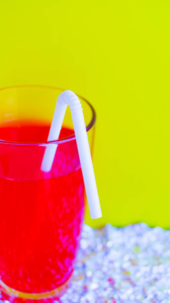 istock White plastic disposable straw in a red summer tasty cocktail on a yellow background. Refreshing drink. Selective focus. 1225401843