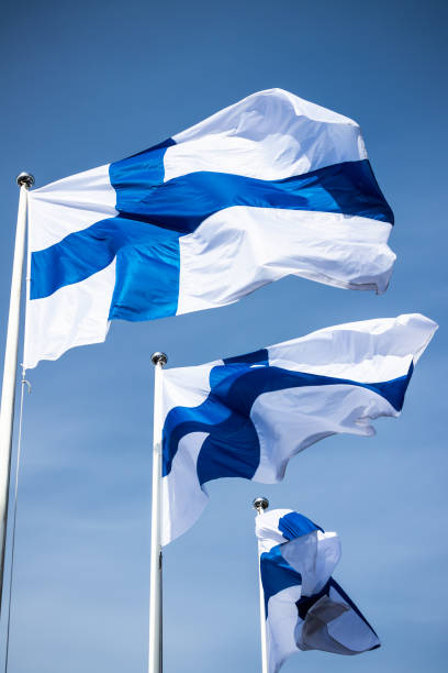 istock Three finnish national flags on the wind against the blue sky 1225403507