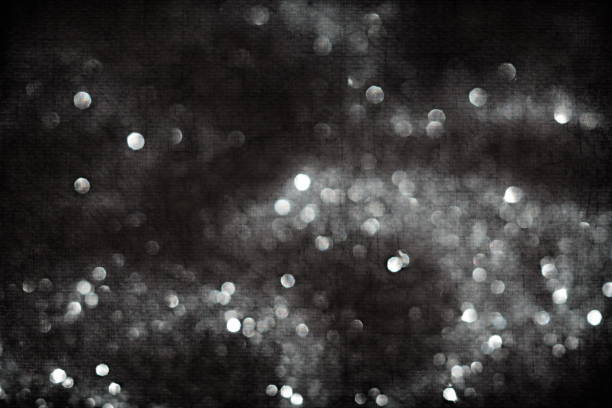 silver sparkles bockeh on black background toned. Festive, X-mas backdrop. Copy space