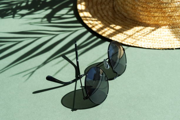 istock sunglasses, straw hat and floral palm shadows on mint background top view. Flat lay creative fashion  lifestyle . 1225406357