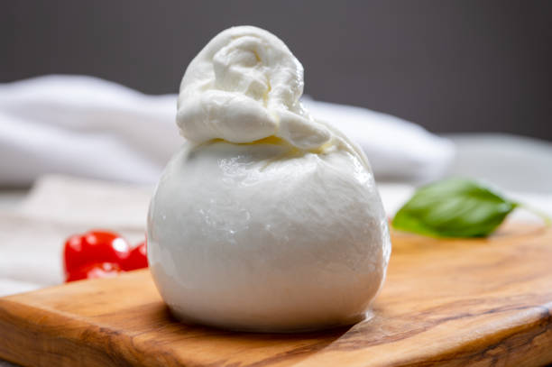 coleção de queijo, bola de queijo burrata branca fresca feita de mussarela e creme de apulia, itália - buratta - fotografias e filmes do acervo