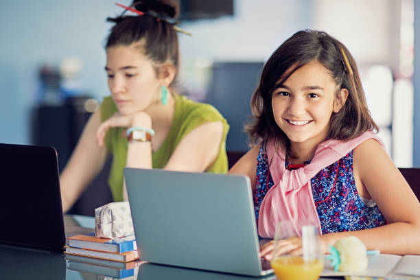 istock Portrait of sisters e-learning at home 1225407658