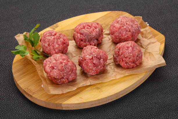 istock Raw meatball over wooden background 1225408945
