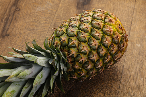 Fresh ripe Pineapple over the wooden background