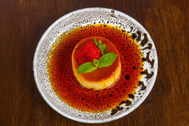 Panna cota with syrope and strawberry served mint