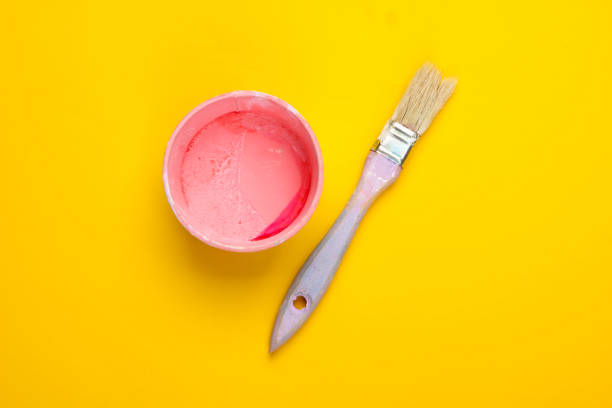 istock Empty can with paint and a brush on a yellow background. Pastel color trend. Top view 1225411905