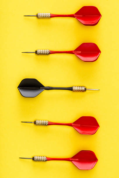 istock Flat lay with black dart among red on yellow background 1225414442