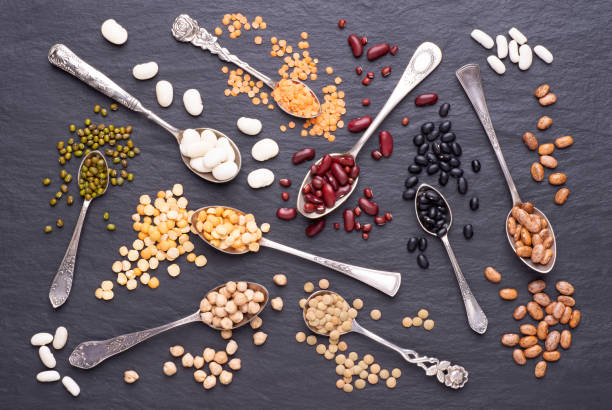 istock Legumes in spoons on stone background. Top view 1225414470