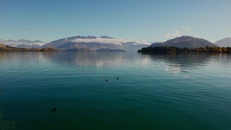 Video clip Drone flying over a beautiful lake By flying to the front There is a reflection of the face And in front of the snow-capped mountains is a concept of relaxation Natural travel