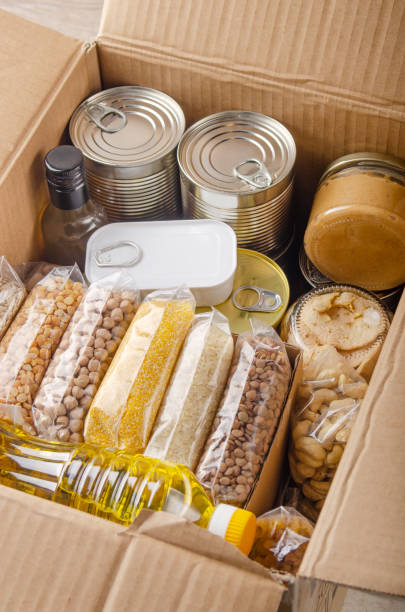 conjunto de alimentos sin cocinar en caja de cartón preparadas para condiciones de emergencia ante desastres o regalando vista de primer plano - non perishable fotografías e imágenes de stock